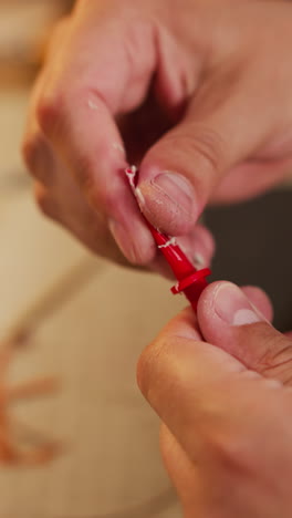 worker cleans plastic brush from glue leftovers at workplace closeup. craftsman works with tool in home studio. traditional industry of accessory making