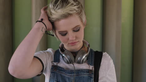 portrait of confident young woman wearing headphones blonde hair alternative