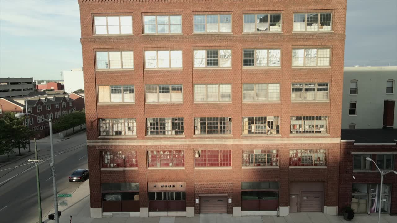 Aerial view of an abandoned building with a woman walking.
