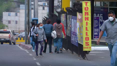 street view of people walking, commuting with face masks, busy cars driving in zone 18 guatemala city, guatemala