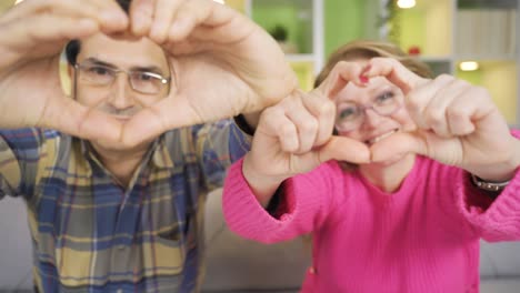 Reifes-älteres-Ehepaar,-Das-Vor-Der-Kamera-Mit-Großem-Glück-Und-Liebe-Ein-Herz-Macht.