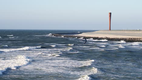 Un-Par-De-Kitesurfistas-Jugando,-Saltando-Y-Girando-En-ásperas-Olas-Tormentosas