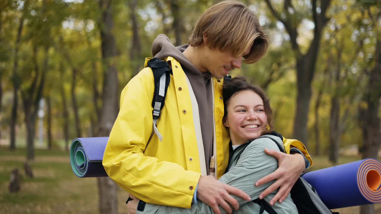 pareja enamorada en el bosque de otoño de pie emracing, viajando con mochila admirar el entorno novia feliz