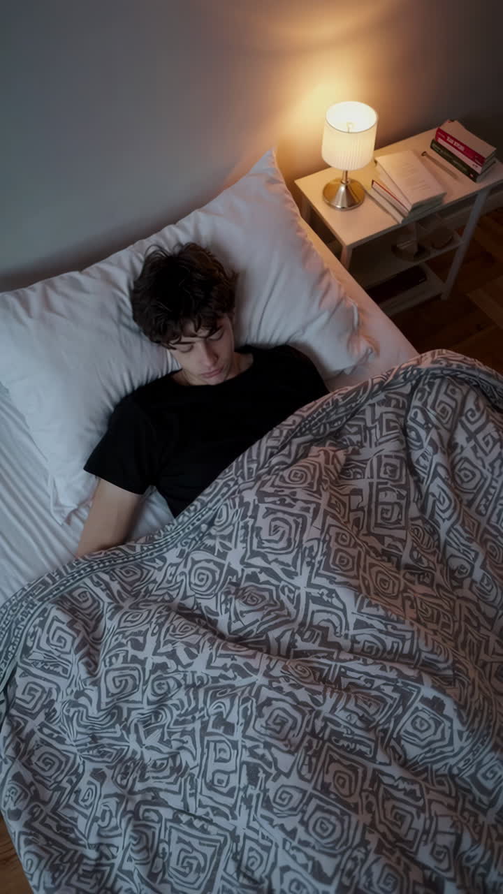 Young Man Sleeping Peacefully in Bed at Night