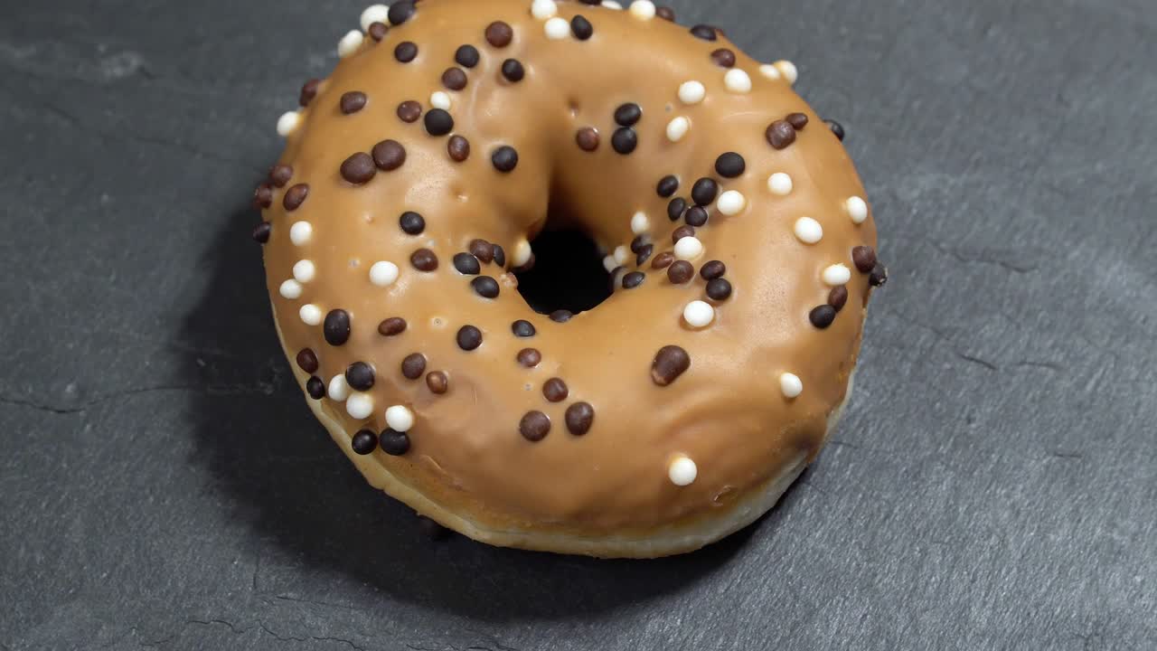 el donut dulce gira sobre un fondo oscuro. la dulzura tradicional estadounidense