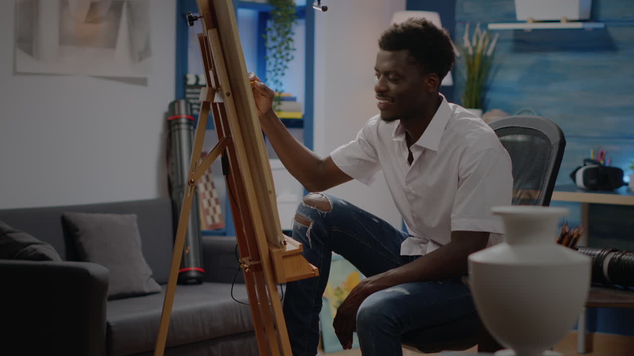 Svart ung voksen som sitter i kunstverk studio tegning vase