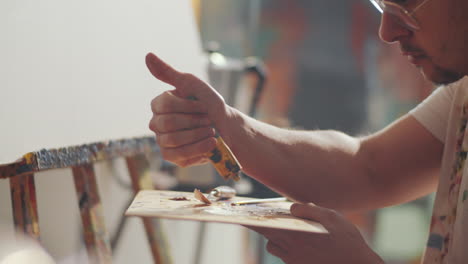 artist pouring paint on palette