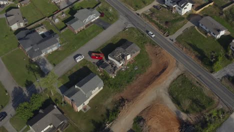 aerial drone tilt down reveal a badly damaged home from storm tornado in suburban setting