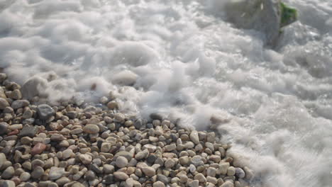 seawater crashing over stones on rugged coastline, natural force concept