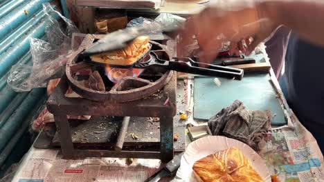 bread toast getting grilled in manual machine in road side stall in kolkata, india