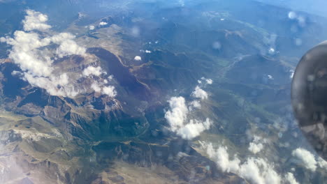 escena de mirar por la ventana viendo maravillosas vistas a la montaña y ver desde un avión volando en el cielo a través de las nubes, el concepto de viaje y transporte