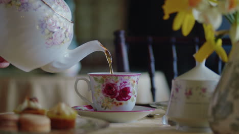 elegant table revealed as tea pot fills a cup of tea