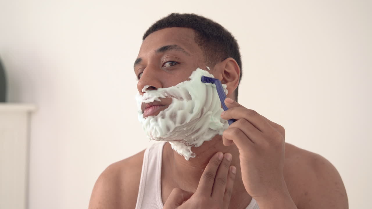 면도칼로 거품 면도를 한 잘생긴 흑인 남자의 초상화