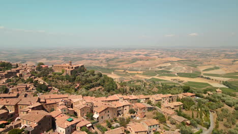 ancient townscape over hills overlooking tuscan valley during summer in montalcino, italy