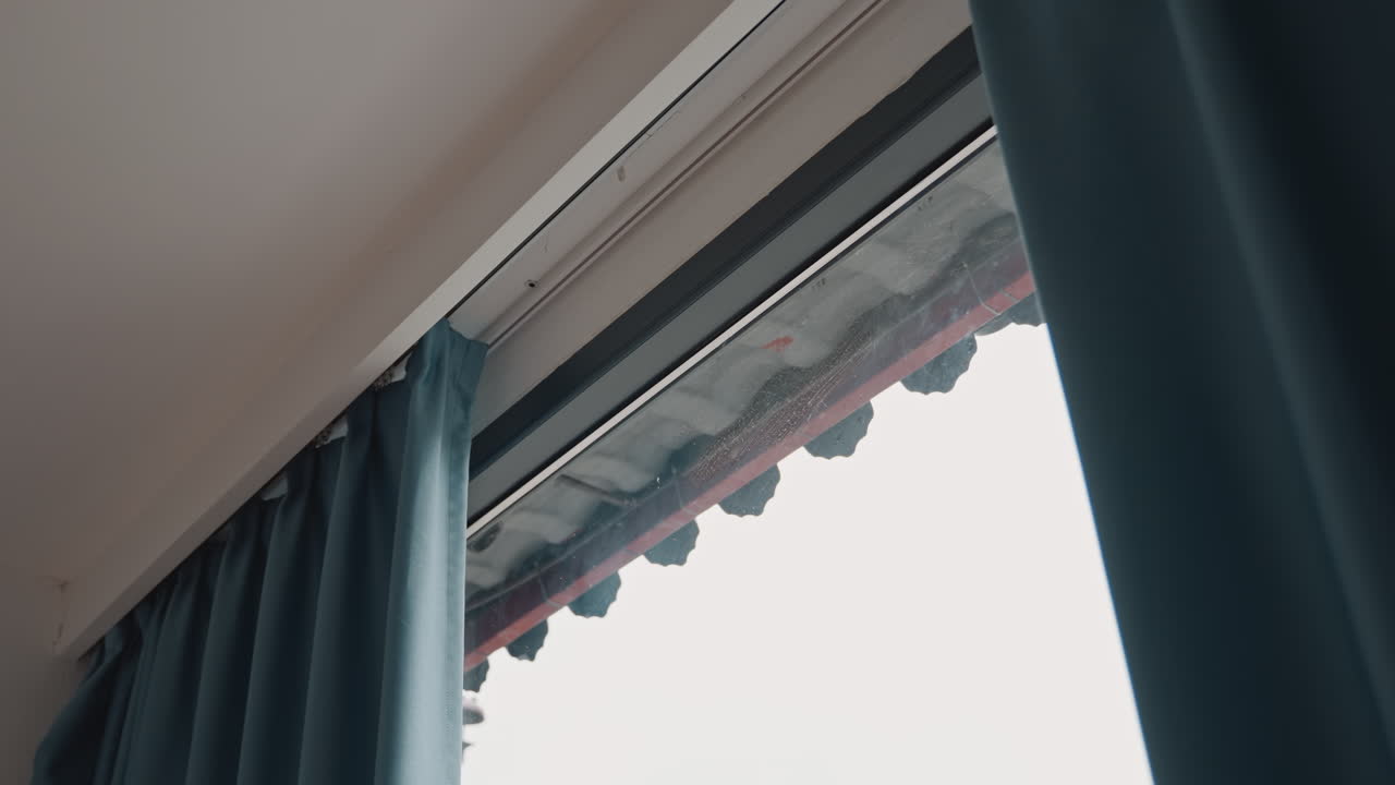 La luce del sole all'alba riempie dolcemente la finestra aperta dell'hotel. Cielo limpido e tende svolazzanti creano un'atmosfera serena. La mattina luminosa e soleggiata proietta un caldo bagliore attraverso le finestre aperte e le tende svolazzanti
