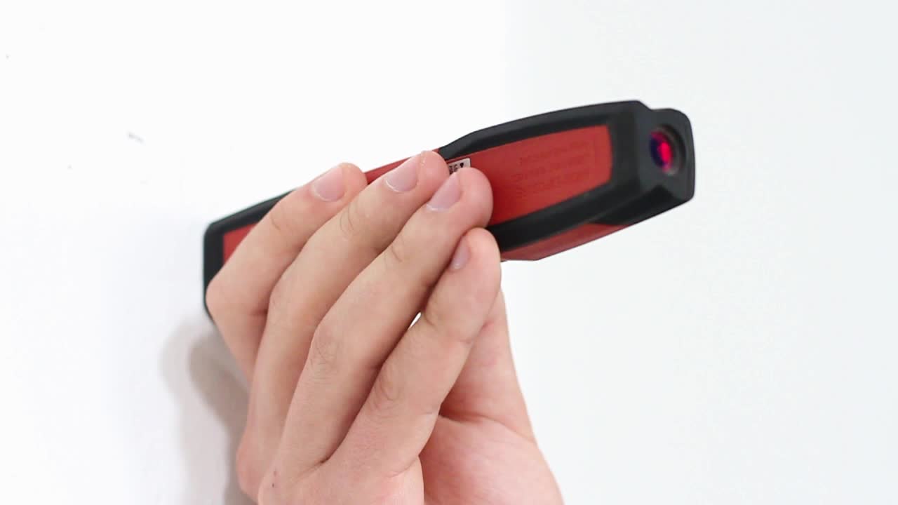 Man measuring with laser tape in white wall background