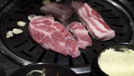 raw pork belly cooked in korean barbeque grill - close up shot