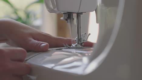 Hands-Of-A-Seamstress-Sewing-Cloth-With-A-Sewing-Machine-At-Home---closeup-shot