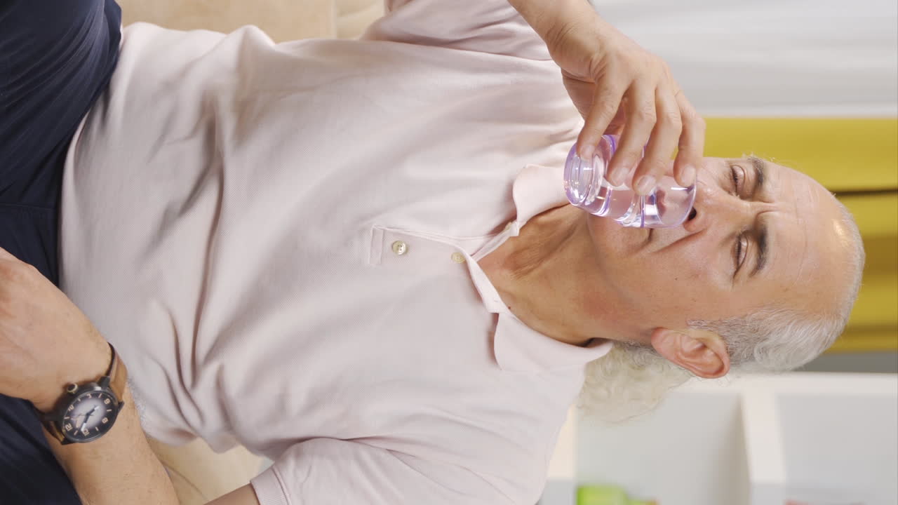 Vertikal video på den äldre mannen som dricker vatten.