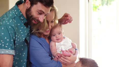 familia sonriente mirando a su hijo