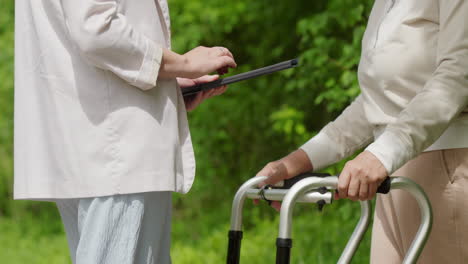 elderly woman assisted by young woman using tablet