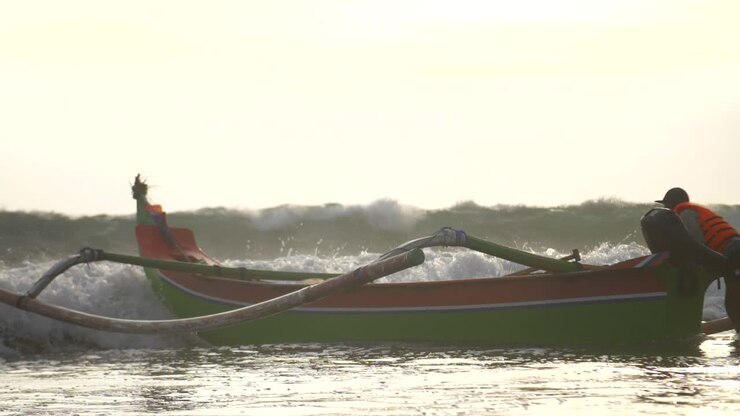 Waves Hitting a Fishing Canoe on a Beach