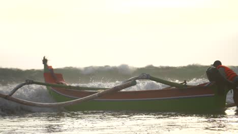 fale uderzające w kajak rybacki na plaży