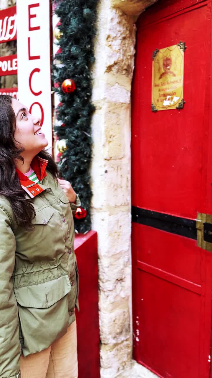 Happy Woman Looking at a Festive Red Door in Jerusalem