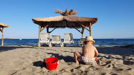 toddler playing in the sand by the sea