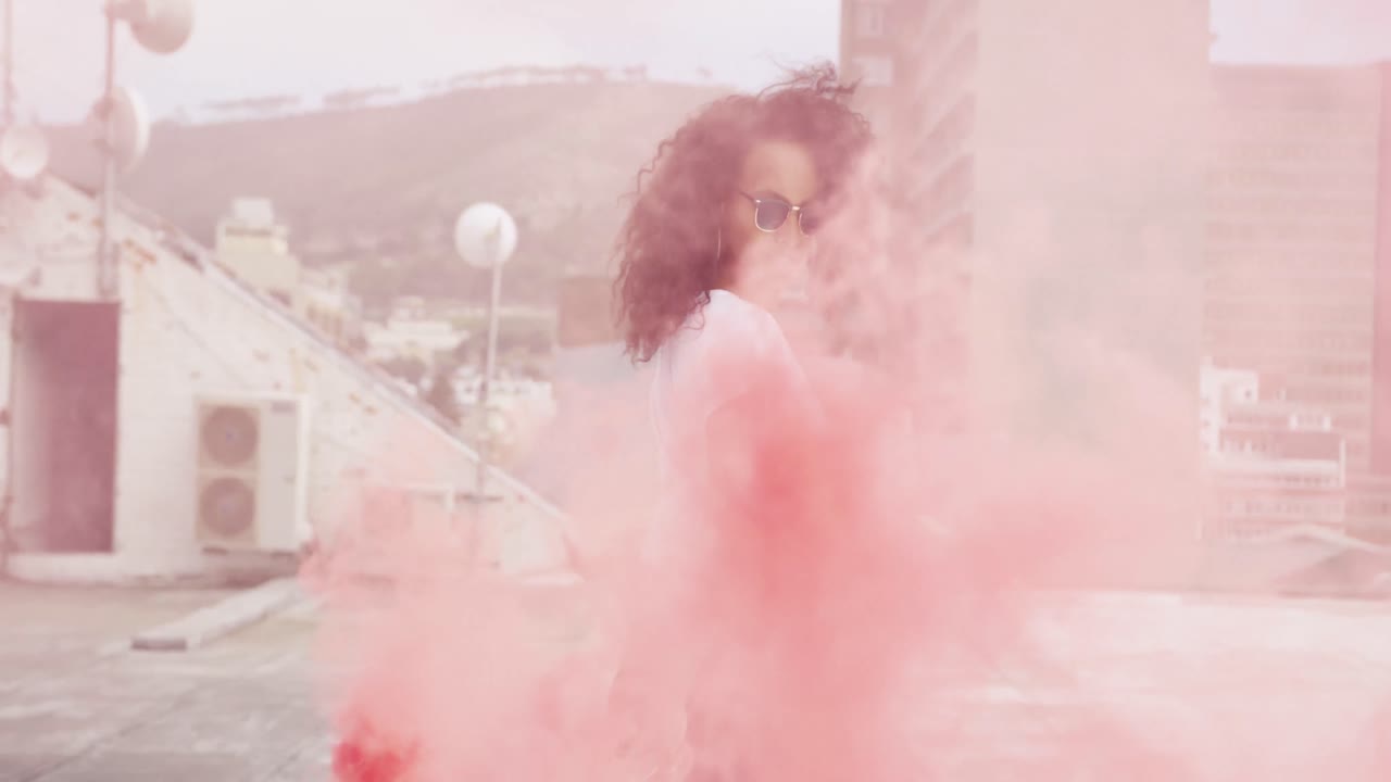 연기 수류탄을 사용하는 도시 지붕에 패션 젊은 여성