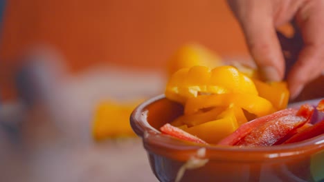 a simple knife cutting of a yellow pepper then puting in a container