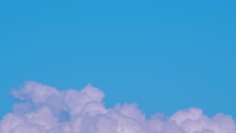 lapso de tiempo de hermosas nubes esponjosas blancas en movimiento rápido y cielo en un día soleado, plano medio