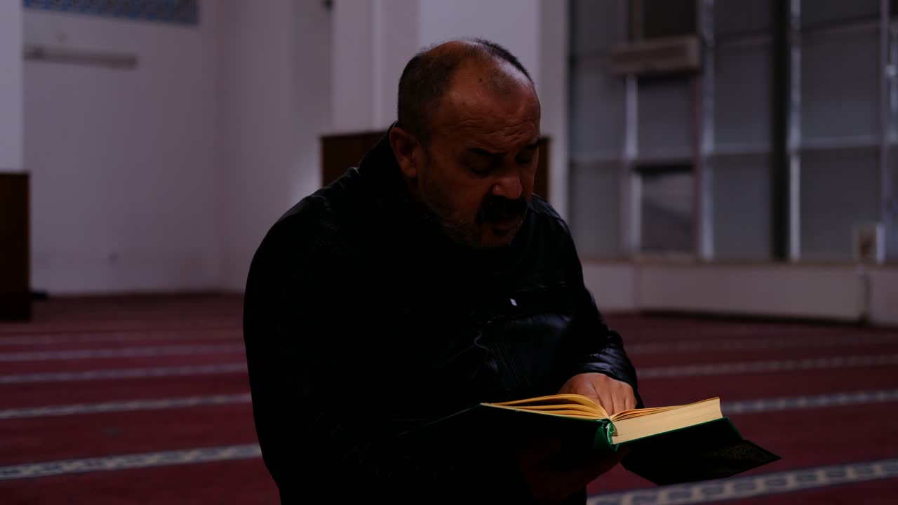 남자는 모스크 2에서 꾸란을 읽습니다.