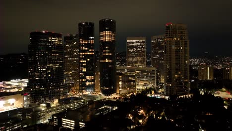 establishing parallax aerial of century city rising at night or sunrise in the dark of the buildings