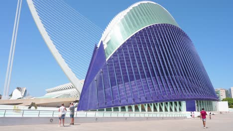 people are seen outside the caixaforum valencia, agora, in the city of arts and sciences. designed by santiago calatrava, it is the most significant modern tourist destination in valencia."