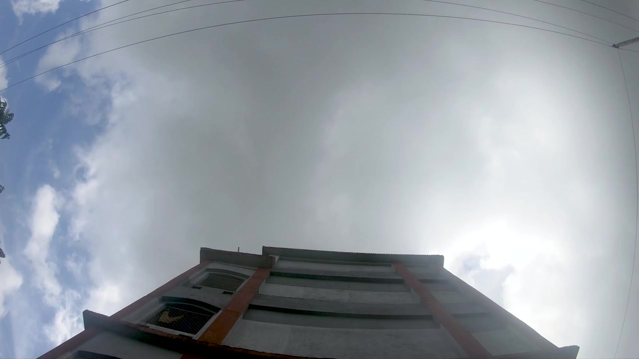 Dramatic time-lapse of heavy storm clouds sweeping over an unfinished building structure, capturing changing weather, urban construction, and atmospheric movement.
