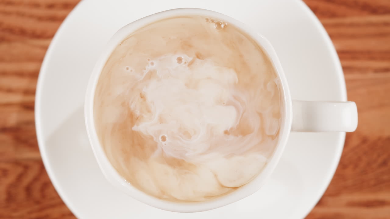 Milk Being Poured into a Mug of Coffee