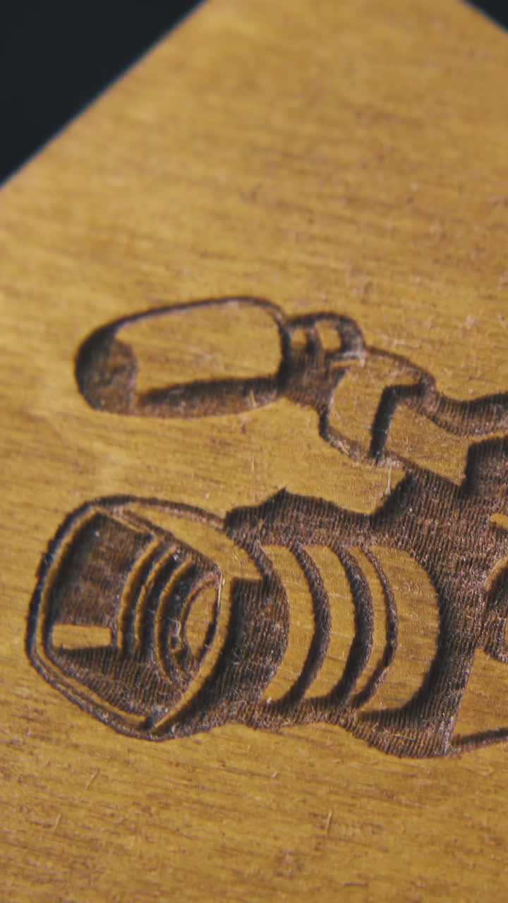 person shows wooden bow tie with camera carved picture and denim cloth on dark background extreme close view