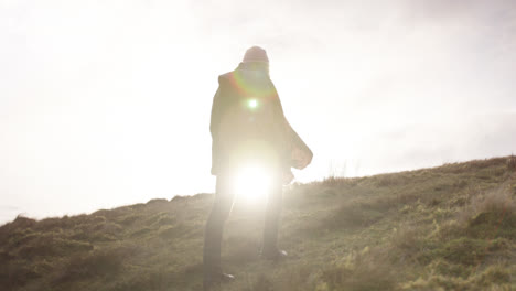 Female-walks-up-hill-in-English-countryside-in-the-sun