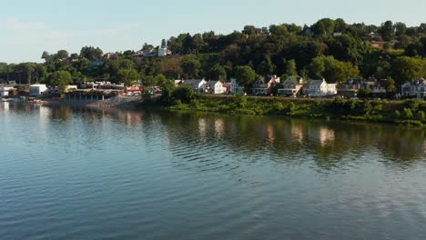 aerial over river by small town community in usa