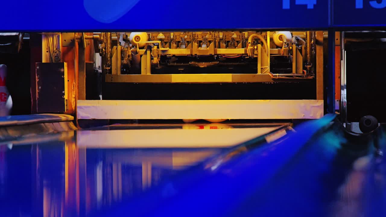 Colorful reflections and smooth slow motion show bowling strike in vibrant scene