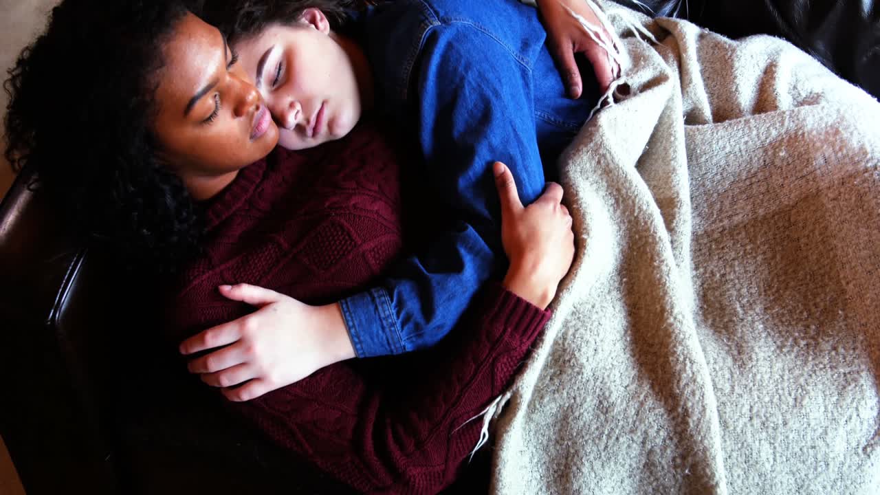 pareja de lesbianas durmiendo juntos en el sofá