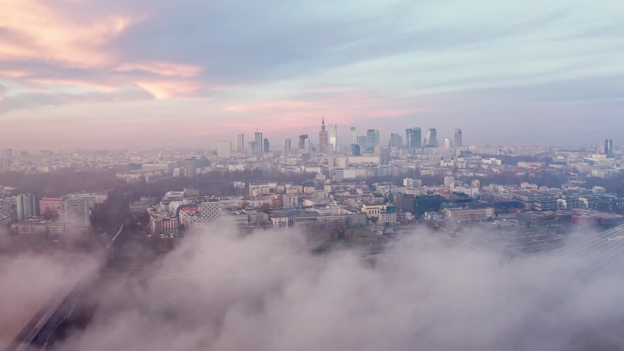 Low clouds flying over Vistula river in Warsaw. Colourful sunrise seen from a drone