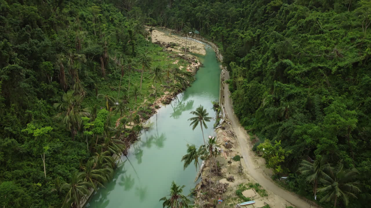 lenta toma aérea cinematográfica moviéndose a lo largo de un río verde en la selva tropical cerca de cebu filipinas, asia, dron