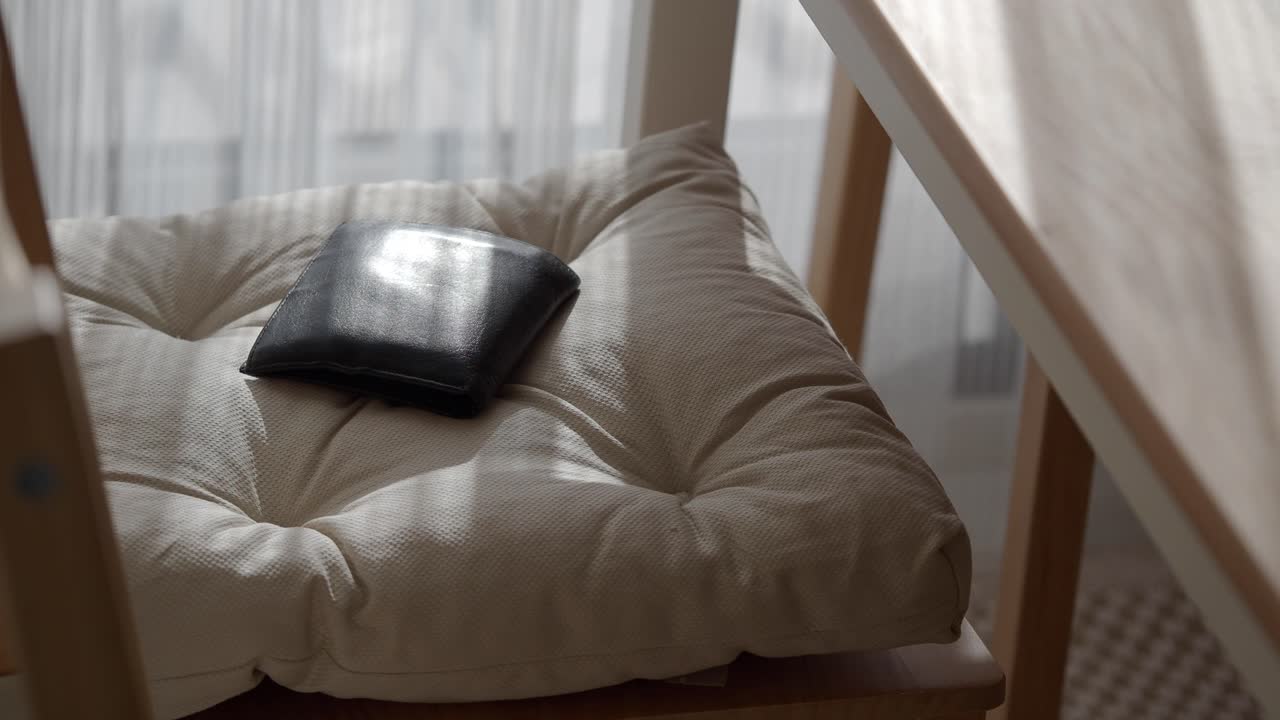 Black Wallet on a Beige Chair Cushion