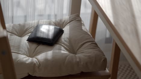 black wallet on a beige chair cushion