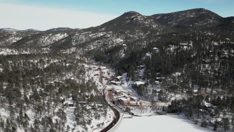 Innenstadt,-Altes-Historisches-Evergreen,-Colorado,-Luftaufnahme,-Drohne,-Filmisch,-Winter,-Frischer-Schnee,-Kaltes-Weiß,-Malerische-Landschaft-In-Der-Nähe-Des-Stausees,-Verkehr,-Herumfahren,-Haus,-Schlittschuhlaufen,-Später-Morgen,-Blauer-Himmel,-Aufwärtsbewegung