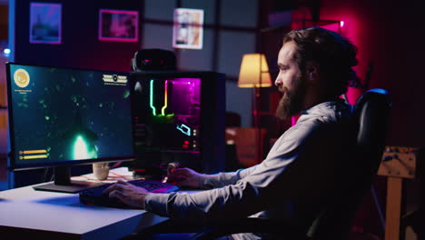 man powering up computer to play videogames after arriving home in neon lit apartment