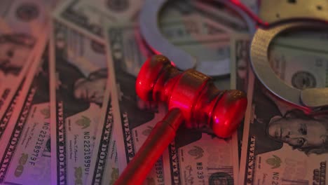 the bribery, fraud of wooden judge gavel with handcuffs us dollar bills in light flashes police