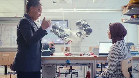 Arabic Future Engineer Ask Female Professor while Developing Programme for Automated Robotic Systems. Black Woman Manipulating Robot Arm. Autonomous Facility Optimisation Concept